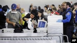 Travelers at John F. Kennedy International Airport in New York go through security screening, 22 Oct 2010