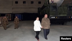 Lãnh tụ Triều Tiên Kim Jong Un cùng với con gái thị sát một phi đạn đạn đạo xuyên lục địa (ICBM) trong bức ảnh không đề ngày tháng này do Thông tấn xã Trung ương Triều Tiên (KCNA) công bố vào ngày 19 tháng 11 năm 2022.