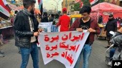 Người biểu tình giăng biểu ngữ viết "Iran, Mỹ hãy ra khỏi Iraq. Baghdad tự do" trong một buổi tọa kháng tại quảng trường Tahrir ở Baghdad, Iraq hôm thứ Tư 8/1/2020. (AP Photo/Qassim Abdul-Zahra)