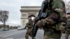 French soldiers cross the Champs Elysees avenue passing the Arc de Triomphe in Paris, Nov. 16, 2015.