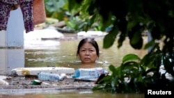 Một phụ nữ đang lội trên một con đường bị ngập lụt trong phố cổ Hội An sau khi bão Damrey thổi qua vào ngày 6/11/2017.