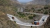 Afghanistan-bound trucks pass through a valley while moving toward the Torkham border crossing in Torkham, Pakistan, Saturday, June 18, 2016. 