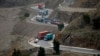 Trucks carry goods on its way to neighboring Afghanistan through the Khyber Pass in Pakistani tribal area, March 21, 2017. A Pakistani border official says hundreds of trucks have crossed into Afghanistan from Pakistan after the border reopened for the fi