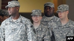 Binh nhất Bradley Manning (giữa) được đưa ra khỏi tòa án ở Fort Meade, bang Maryland