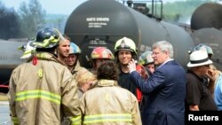 Thủ tướng Canada Stephen Harper nói chuyện với nhân viên cứu hỏa trong khi ông đi thị sát sau khi tai nạn xảy ra, 7/7/13