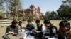 Students exchange their notes after attending a class at Pakistan's Punjab University in Lahore February 12, 2008. Students at Punjab University, the country's biggest and traditional nursery for politicians, are disillusioned with politics and many say t