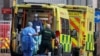 Medics transport a patient from an ambulance to the Royal London Hospital as the spread of the coronavirus disease (COVID-19) continues in London, Britain, Jan. 1, 2021.