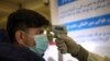 An Afghan health worker takes the temperature of a passenger as a preventive measure for Coronavirus, during screening of travelers who arrived from China, at the Hamid Karzai International Airport in Kabul, Afghanistan, Monday, Feb. 3, 2020…