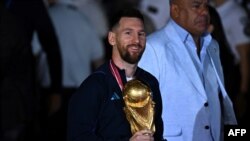 Đội trưởng, tiền đạo đội tuyển Argentina, Lionel Messi, cầm chiếc Cúp FIFA World Cup khi đến Sân bay Quốc tế Ezeiza sau khi vô địch giải đấu World Cup Qatar 2022, vào ngày 20 tháng 12 năm 2022.