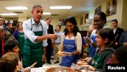 Tổng thống Barack Obama gặp gỡ trẻ em và các tình nguyện viên trong một chuyến thăm tới Martha's Table, một căn bếp chuẩn bị bữa ăn cho người thiếu thốn ở Washington 14/10/2013.