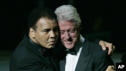 Huyền thoại quyền anh Muhammad Ali (trái) ôm cựu Tổng thống Hoa Kỳ Bill Clinton khi bước lên sân khấu trong buổi lễ khai trương Trung tâm Muhammad Ali ở Louisville, Kentucky, ngày 19 tháng 11 năm 2005.