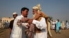 Afghans greet one another after performing prayers during the annual festival of Eid al-Adha or the Festival of Sacrifice at Kacha Garhi Afghan refugee camp, on the outskirts of Peshawar October 4, 2014. Muslims around the world celebrate Eid al-Adha to m