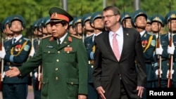 Bộ trưởng Quốc phòng Việt Nam Phùng Quang Thanh đón tiếp Bộ trưởng Quốc phòng Mỹ Ashton Carter trong một buổi lễ tại Hà Nội ngày 1/6/2015. 