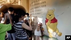 Một em nhỏ chụp hình với bức bích họa chú gấu Winnie the Pooh ở Thượng Hải, Trung Quốc, ngày 8 tháng 8, 2018. 