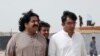 FILE PHOTO: Ali Wazir, left, and Mohsin Dawar, leaders of the Pashtun Tahaffuz Movement (PTM) walk at the venue of a rally against, what they say, are human rights violations by security forces, in Karachi, Pakistan, May 13, 2018. 