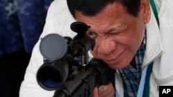 Tổng thống Philippines Rodrigo Duterte kiễm tra súng trường tại căn cứ không quân Clark ở miền bắc Philippines. Ông Duterte tuyên bố sẽ "ăn sống nuốt tươi" Abu Sayyaf vì đã chặt đầu thủy thủ Việt Nam.