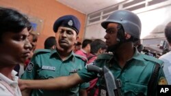 Cảnh sát Bangladesh ngăn đám đông bên ngoài một tòa nhà nơi 2 nhà hoạt động bênh vực người đồng giới tính đã bị sát hại tại Dhaka bởi một băng đảng mang mã tấu, ngày 25/4/2016.