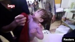 Một em bé được rửa mặt sau vụ tấn công bằng vũ khí hóa học tại Douma, Syria (ảnh ngày 8/4/2018)