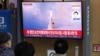 People watch a TV broadcasting a news report on North Korea's intercontinental ballistic missile (ICBM) test, in Seoul