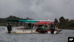 Soldiers and rescue workers flat at the site where a ferry sank in a reservoir in Guatape, Colombia, June 25, 2017. 