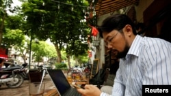 Blogger Nguyễn Chí Tuyến ở quán cafe Internet trên đường phố Hà Nội.